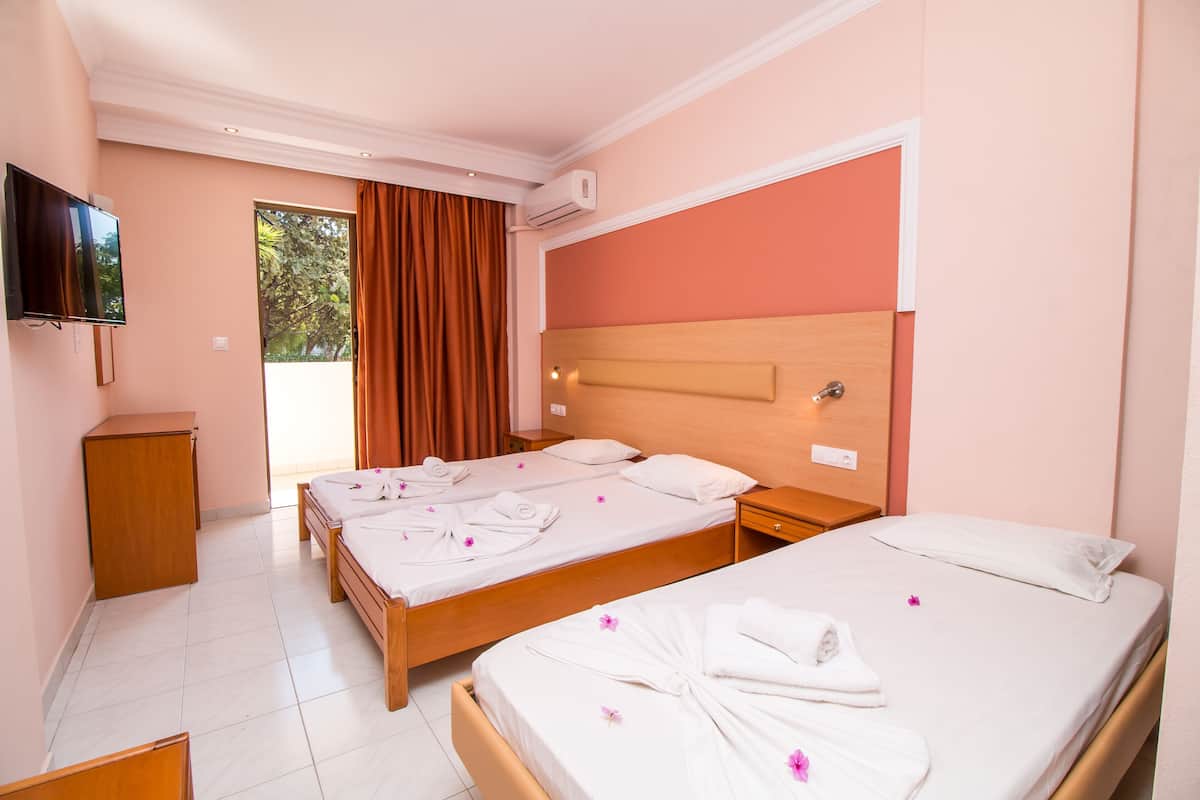 Une chambre d’hôtel avec deux lits, une télévision et un petit bureau.