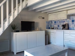 Eine moderne Küche mit weißen Schränken, einem eingebauten Backofen und einer Kaffeemaschine.