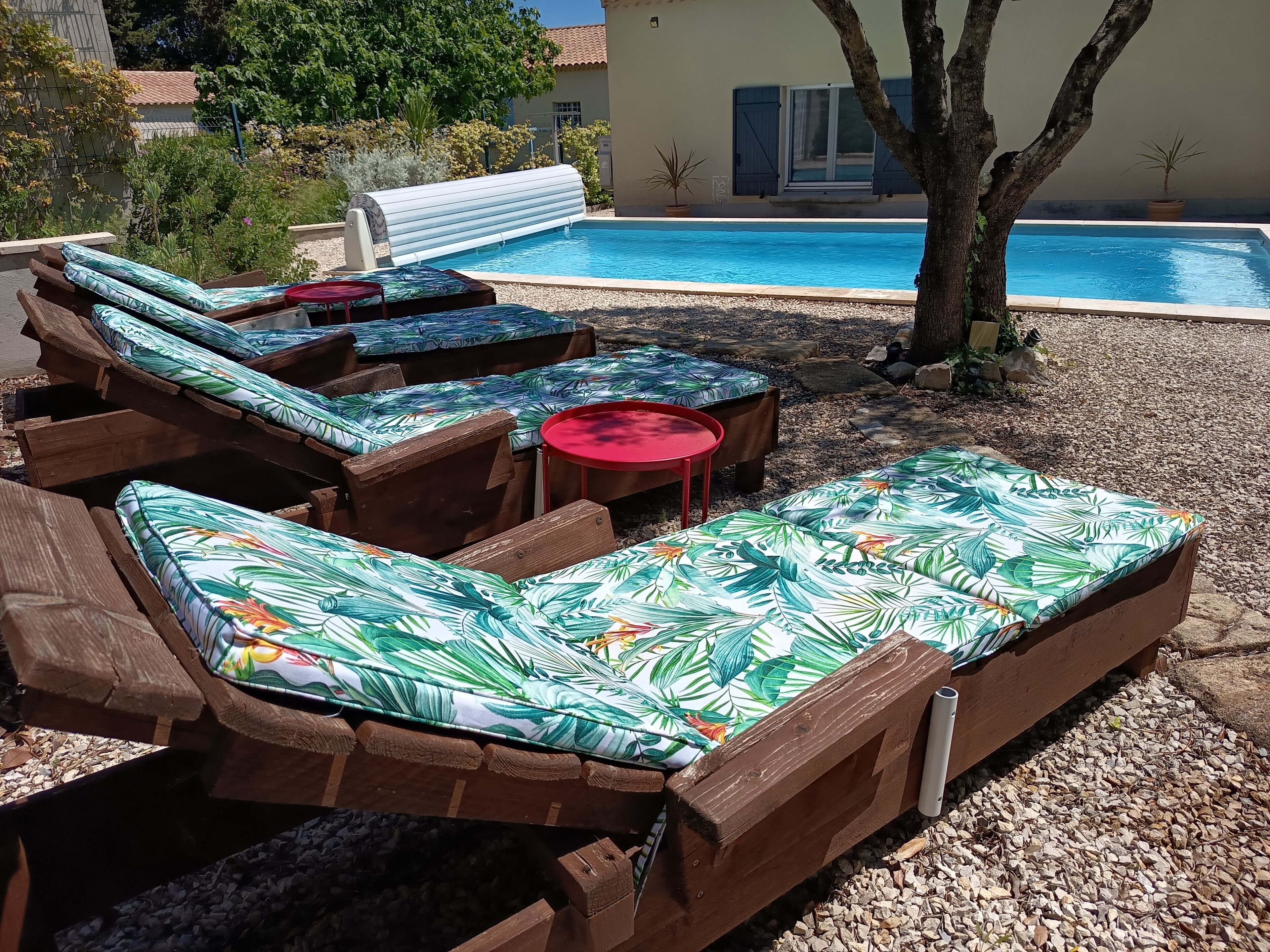 A poolside area with wooden lounge chairs and a small table.