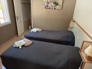 A hotel room with two beds, a window, a shower, and a painting on the wall. - Entire private gîte (Lédenon)