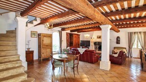 A spacious living area with a fireplace, a television, and a staircase leading to another level. - Luxurious home in Apt (Apt)