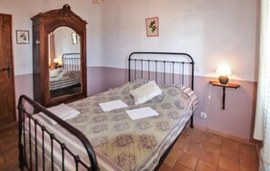 A bedroom with a bed, a bedside table with a lamp, a wall-mounted mirror, and a small picture frame. - Luxurious home in Apt (Apt)