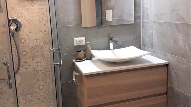A bathroom with a shower, a sink, and a mirror. - NEW HOUSE, & FENCED GARDEN, PRIVATE PARKING NEAR BEACHES. (POSADA)