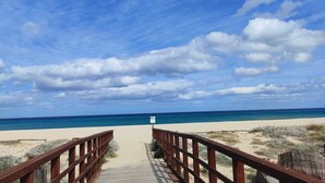 A wooden boardwalk leading to a beach with a clear view of the ocean and a cloudy sky. - NEW HOUSE, & FENCED GARDEN, PRIVATE PARKING NEAR BEACHES. (POSADA)