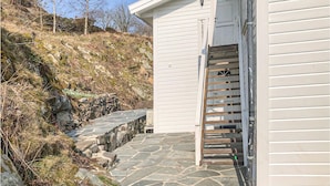 Una escalera de piedra que lleva a un edificio blanco con una puerta de madera.