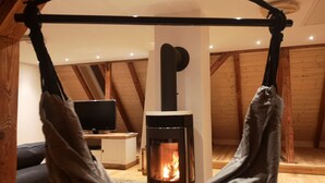Une pièce confortable avec une cheminée, un téléviseur et un hamac.