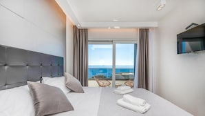 A hotel room with a large bed, a TV, and a balcony with a view of the sea. - Lovely home in Makarska (Makarska)