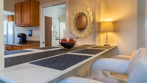 Une cuisine moderne avec des meubles en bois, une machine à café et un miroir décoratif.