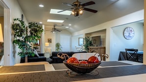 Un espace repas comprenant une table, des chaises, un ventilateur de plafond et une horloge murale.