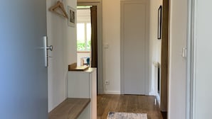 A hallway with a wooden floor, a blue and white patterned rug, a white door, and a ceiling light. - Idyllische Ferienwohnung in Potsdam (Potsdam)