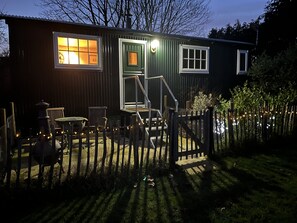 A wooden cabin with a porch, a small table, and a chair. - SHEPHERD'S RETREAT (Alderholt)