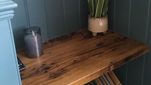 Un banc en bois, avec un pot de fleurs et un chandelier.