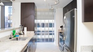 Een moderne keuken met roestvrijstalen apparatuur, een groot raam en een minimalistisch ontwerp.