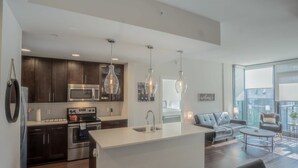 A modern kitchen with dark wood cabinets, stainless steel appliances, and pendant lighting. - 3380 Peachtree Rd NE Atlanta, GA 30326, USA (Atlanta)