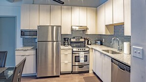 Una cucina moderna con elettrodomestici in acciaio inossidabile, forno integrato e macchina del caffè.