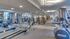 Een moderne sportschool met diverse fitnessapparaten, grote spiegels en een ruime indeling.