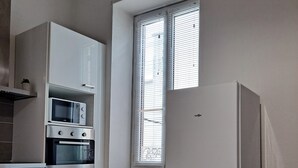 Een praktische keuken met een magnetron, oven en koelkast.