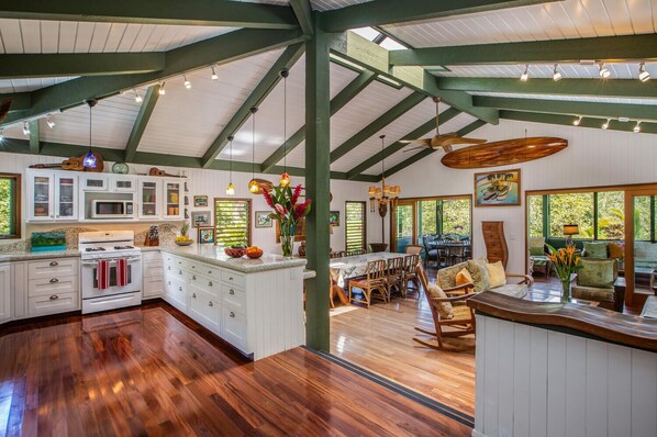 Enjoy cooking in the well-equipped kitchen with a central island, stainless steel stove, and pendant lights.
