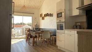 Une cuisine moderne avec des meubles en bois, un four encastré et un four à micro-ondes.