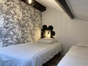 Une chambre à coucher avec un lit, une table de chevet et un luminaire fixé au mur.