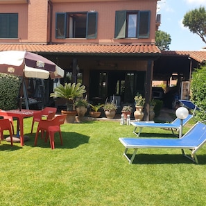 A house with a covered patio, outdoor furniture, and potted plants. - 3 Bedrooms Villa Sleeps 6 With Garden (Rome)