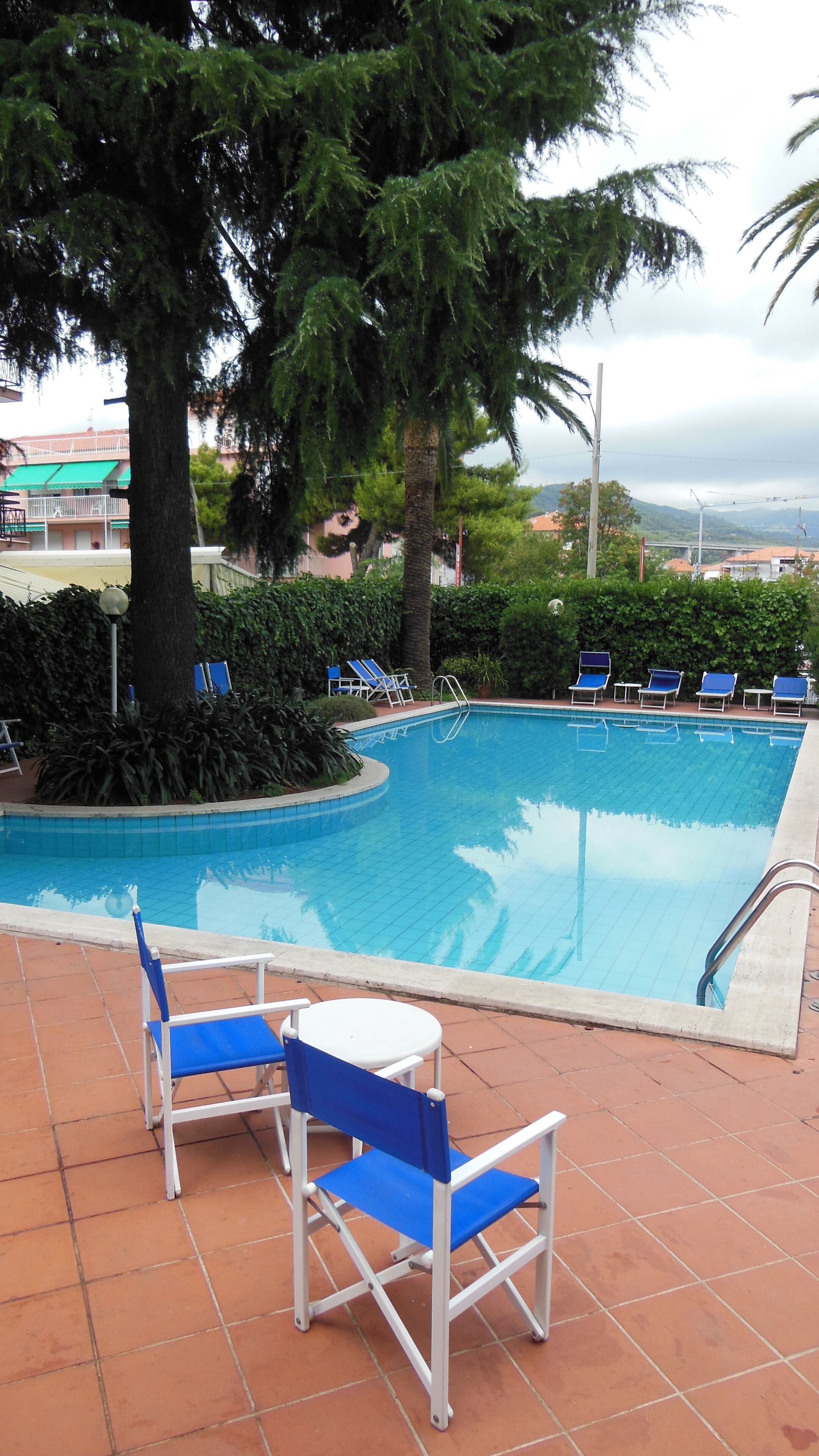 Una piscina al aire libre de temporada, sillones reclinables de piscina