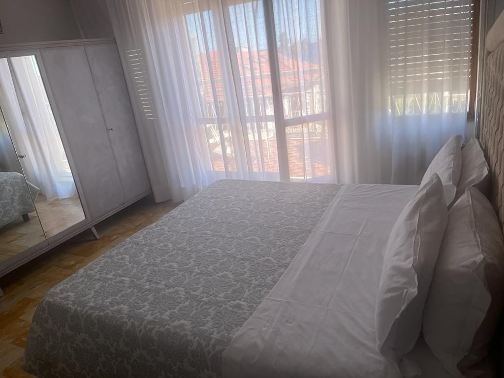 Une chambre à coucher avec un grand lit, une armoire et un miroir.