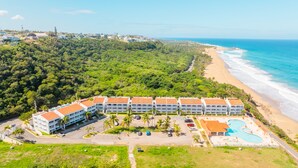Resort com vários edifícios, praia e piscina.