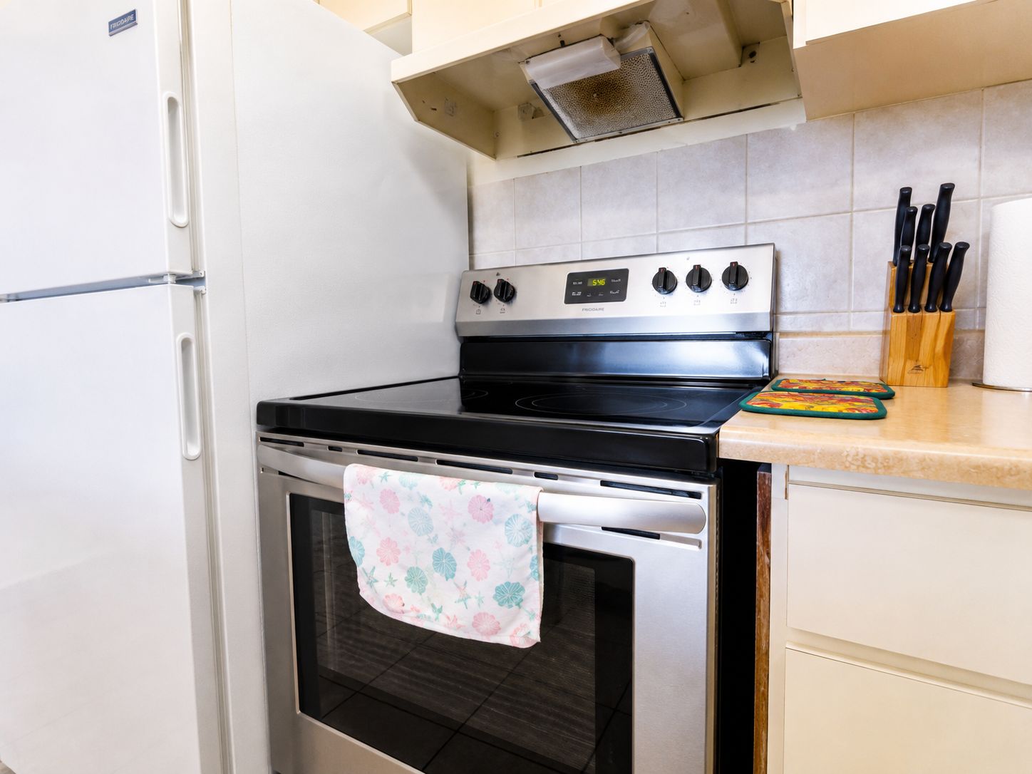 A kitchen with a stainless steel stove, oven, and a refrigerator.