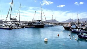 A marina with multiple sailboats docked, calm water, and a mountainous backdrop. - Home2Book Sea Front Attic Las Galletas (Costa del Silencio)