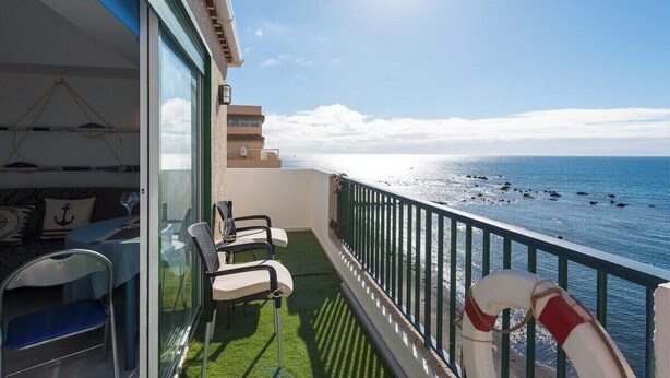 A balcony with a view of the sea, a lifebuoy, and a table with chairs. - Home2Book Sea Front Attic Las Galletas (Costa del Silencio)