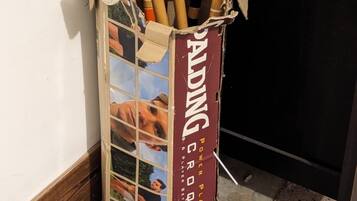 Una caja de cartón etiquetada como 'Palding Croquet Set' con una colección de mazas y pelotas de croquet.