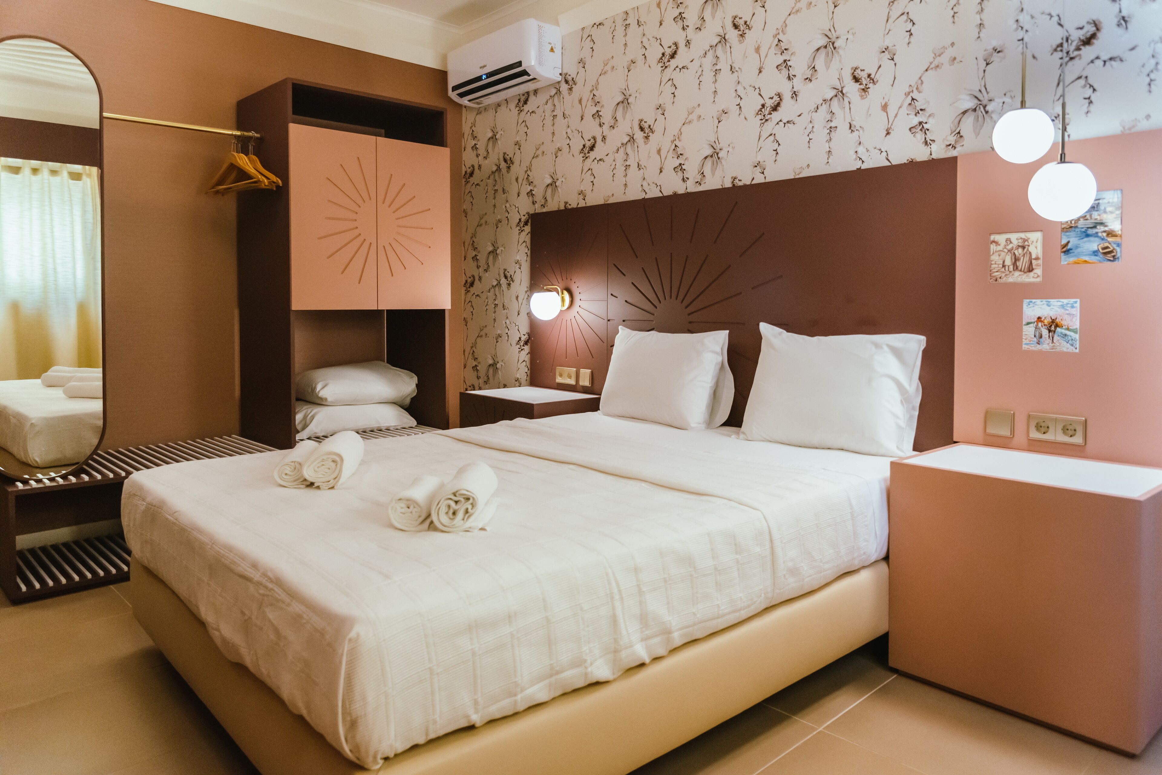 Une chambre d’hôtel avec un grand lit, une table de chevet, un miroir et un climatiseur fixé au mur.