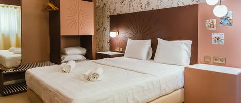 Une chambre d’hôtel avec un grand lit, une table de chevet, un miroir et un climatiseur fixé au mur.