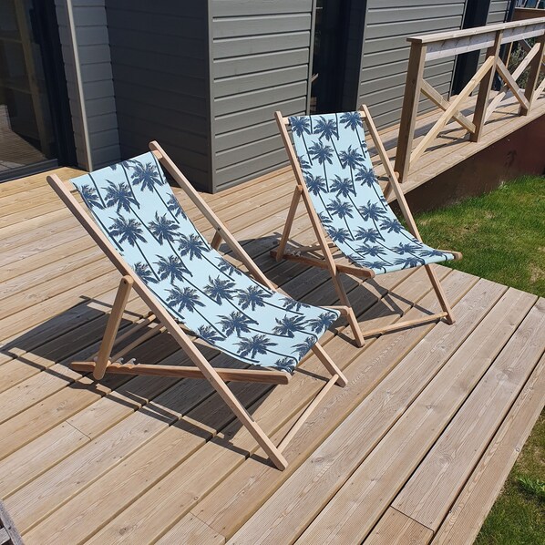 Two wooden deck chairs with blue cushions featuring palm tree prints. - Gîte La Tribu - Sleeps 6, 600 m from the beach (LES MOITIERS D'ALLONNE)