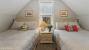 A bedroom with two beds, a window with blinds, a nightstand with a lamp, and decorative pillows. - (2027 OPEN!) New Buffalo Home With Private Pool and Hot Tub! (New Buffalo)