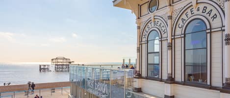 A waterfront cafe with outdoor seating overlooking the sea.