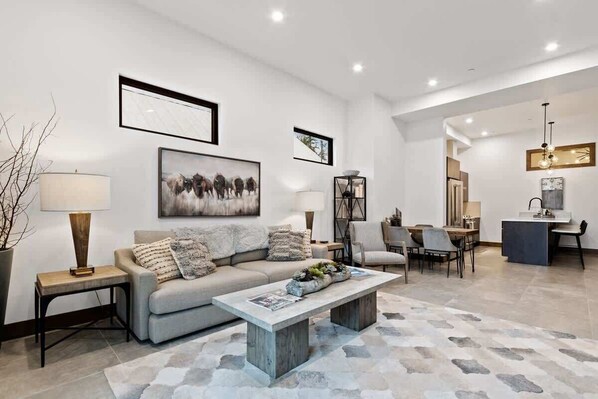 Una sala moderna con sofá, mesa de centro y comedor.