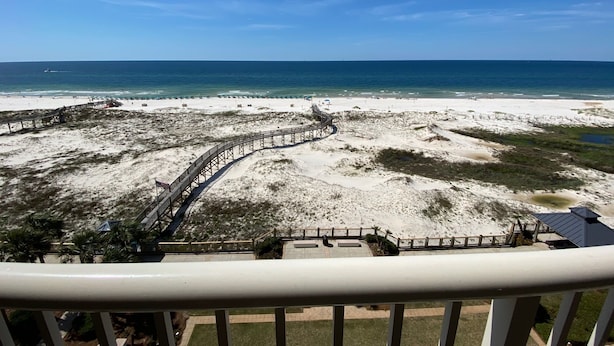 A beach view from a balcony with a wooden boardwalk leading to the shore. - Beach Club Resort. Book Your Summer Vacation Now! My Rates are Hard to Beat! (Gulf Shores)