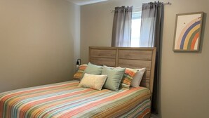 Ein Schlafzimmer mit Bett, Vorhängen und einer Wandleuchte.