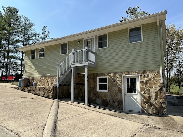 A two-story building with a stone facade, a balcony, and a small porch. - Twin Lake Retreat Nestled on 20 acres, Ponds, Hot Tub, close to Athens (Albany)