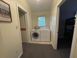 A laundry room with a washing machine and dryer, a window, and a sign on the wall. - Twin Lake Retreat Nestled on 20 acres, Ponds, Hot Tub, close to Athens (Albany)
