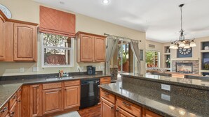 A spacious kitchen with wooden cabinets, granite countertops, and a dishwasher. - Beautiful & Spacious Westside Townhouse, Sleeps 8  w/ A/C.  (Flagstaff)
