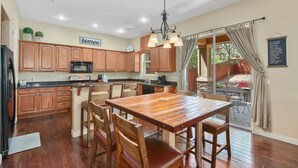 A spacious kitchen with wooden cabinets, a central island, and a dining area with wooden chairs. - Beautiful & Spacious Westside Townhouse, Sleeps 8  w/ A/C.  (Flagstaff)