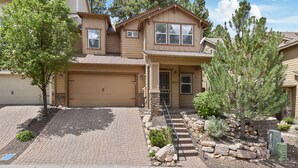 A two-story house with a garage, a front porch, and a stone pathway leading to the front door. - Beautiful & Spacious Westside Townhouse, Sleeps 8  w/ A/C.  (Flagstaff)