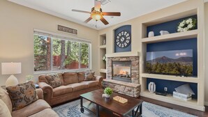 A living room with a fireplace, a sofa, a coffee table, and a television. - Beautiful & Spacious Westside Townhouse, Sleeps 8  w/ A/C.  (Flagstaff)