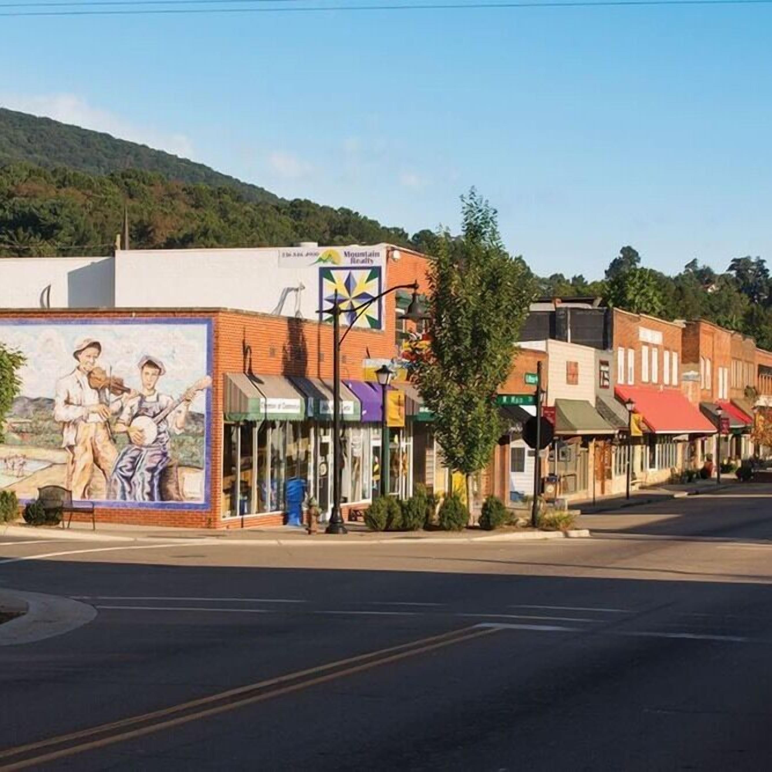 Une vue de rue avec des bâtiments, une fresque murale et une enseigne indiquant « Mountain Realty ».