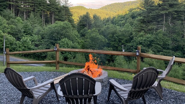 A deck with a fire pit and chairs overlooking a forested area. - SUMMER SPECIAL — Book 5 nights 6+7th FREE — LOG CABIN with Privacy+ Firepit (West Jefferson)