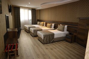 Habitación de hotel con dos camas, un escritorio y un armario.