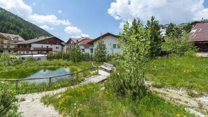 Un quartier résidentiel avec des maisons, un étang et un pont en bois.